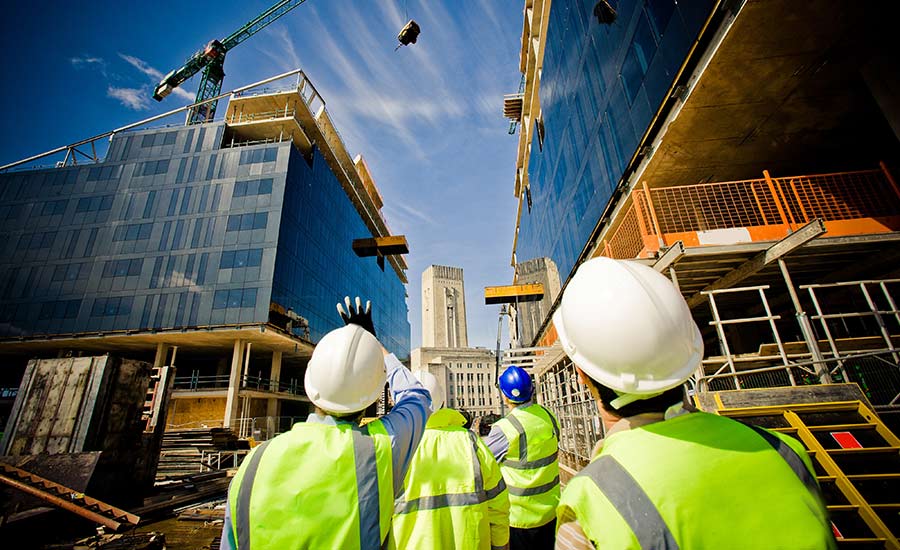 Workers looking at a building under construction​