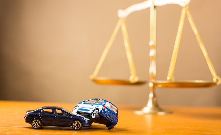 Scales of justice next to two car toys – the concept of legal counsel after a car accident​