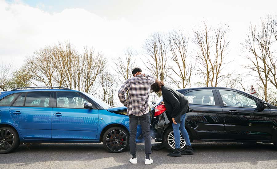 Two drivers looking at their damaged cars​