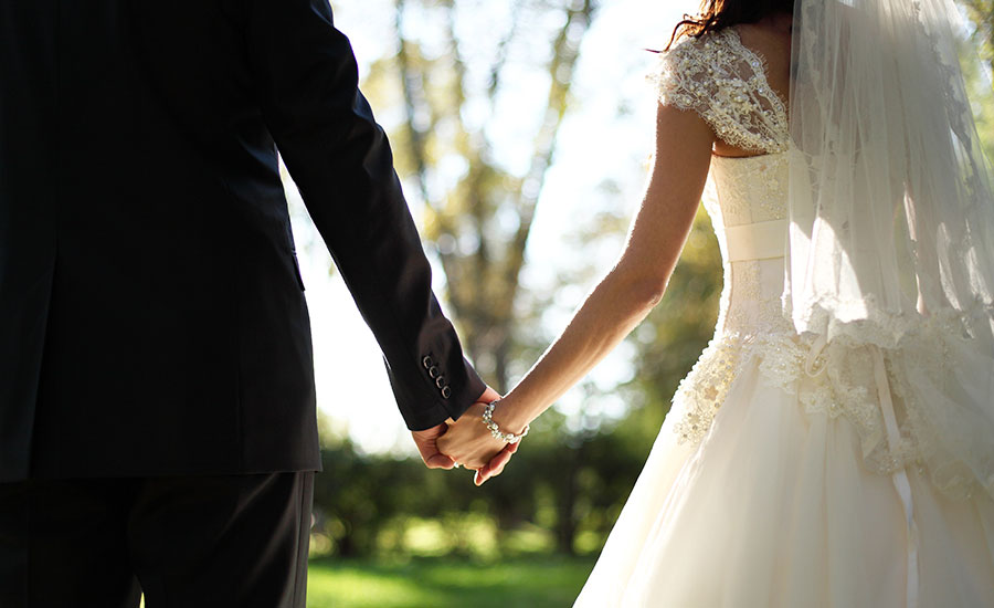 A newly wed couple holding hands​