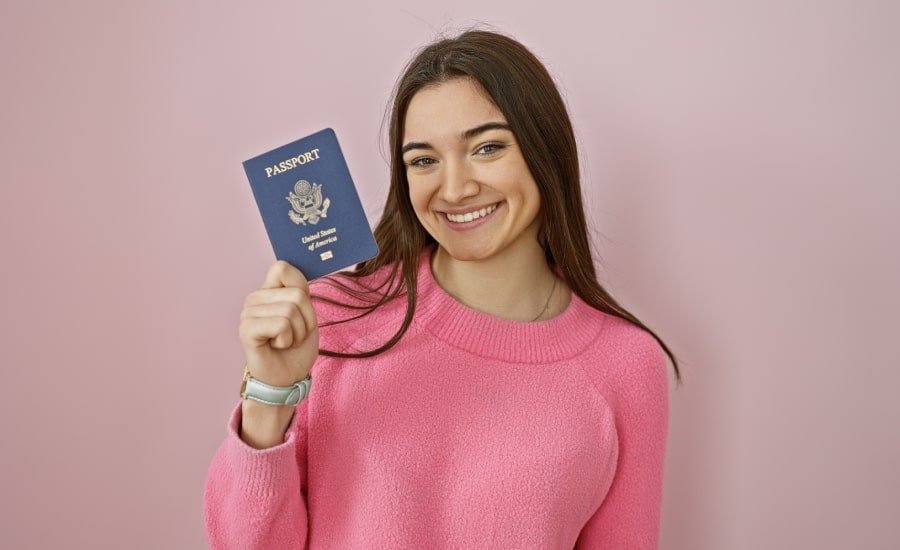 A smiling young woman holding a U.S. passport