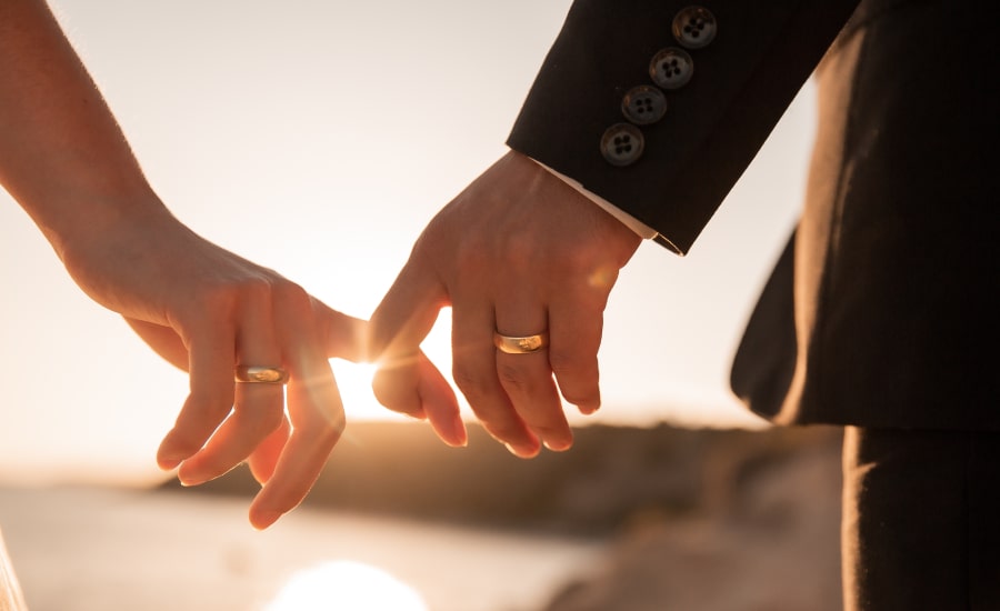 A couple holding hands at sunset​