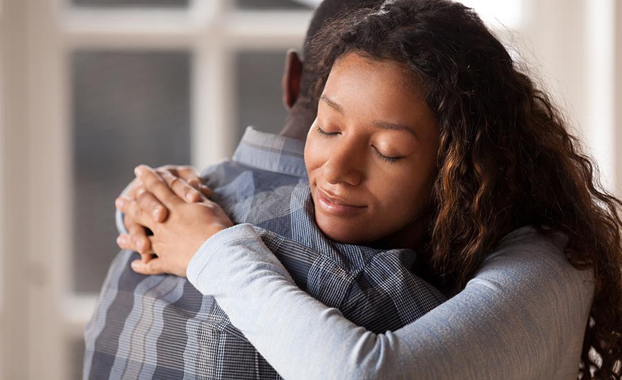 A woman hugging her husband